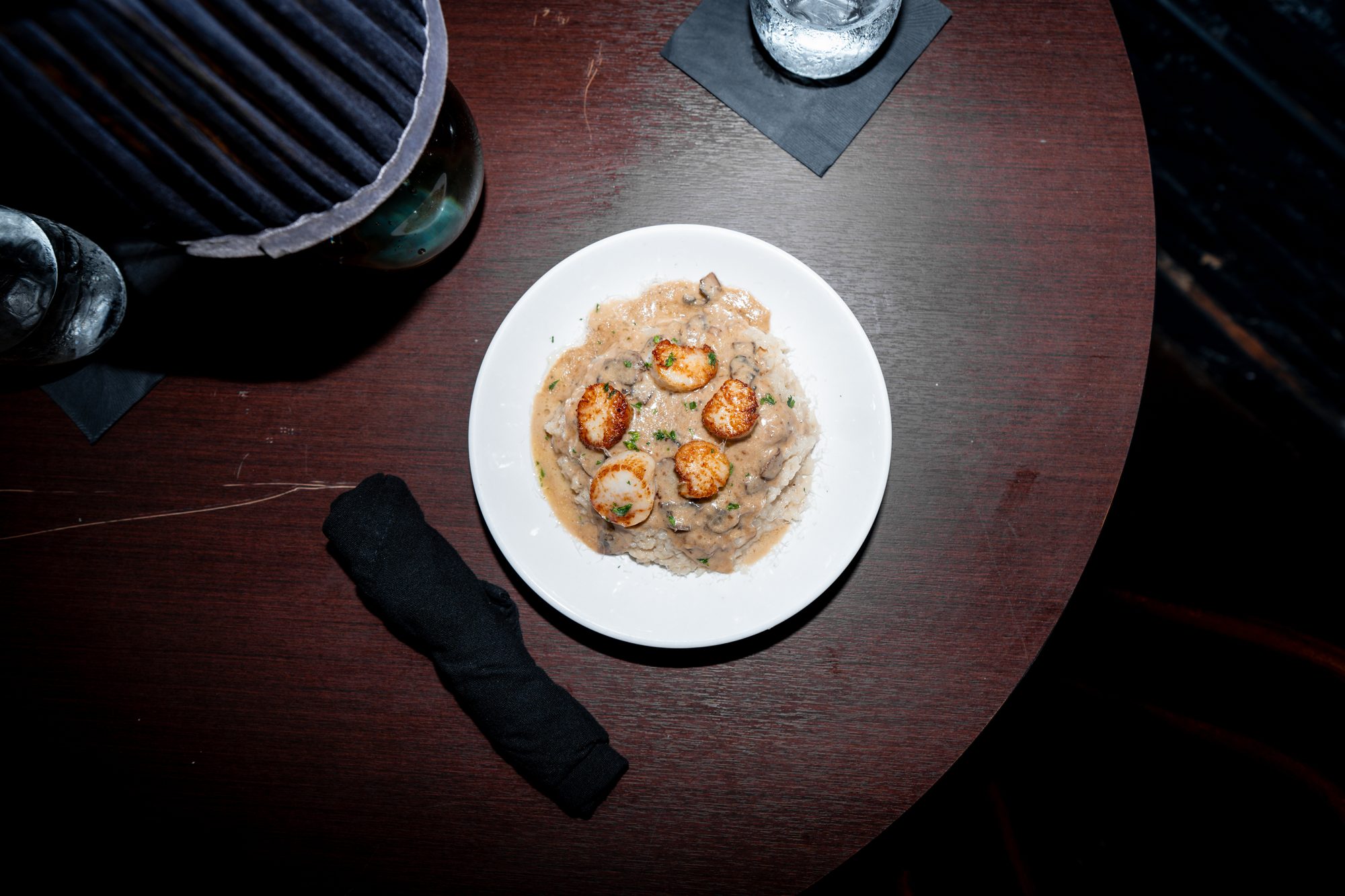 Creamy seafood risotto plated under warm lamp light