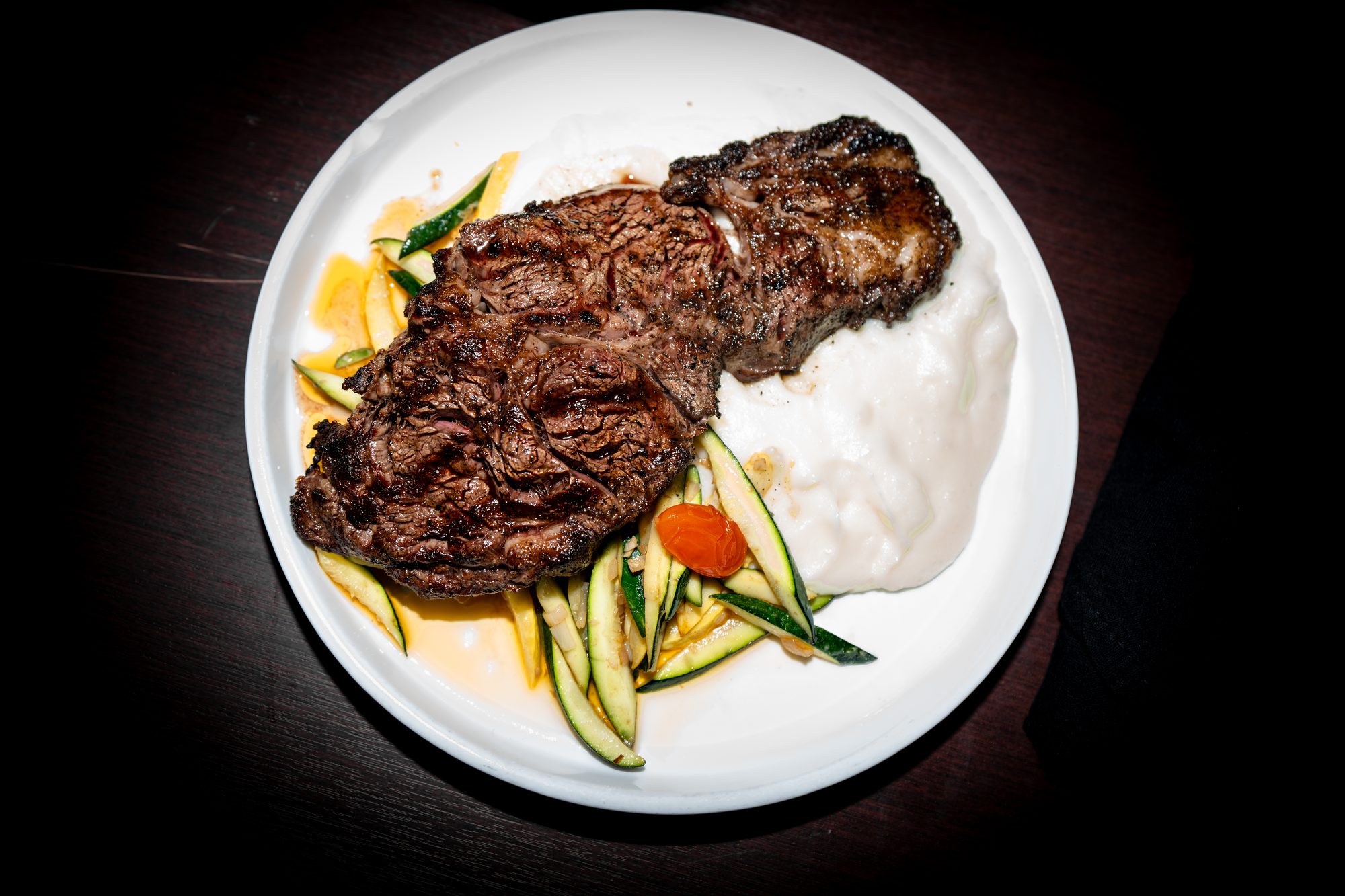 Grilled steak over whipped potato with seasonal vegetables
