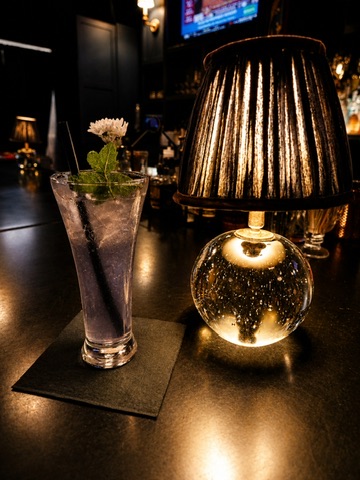 Cocktail finished with a purple floral garnish