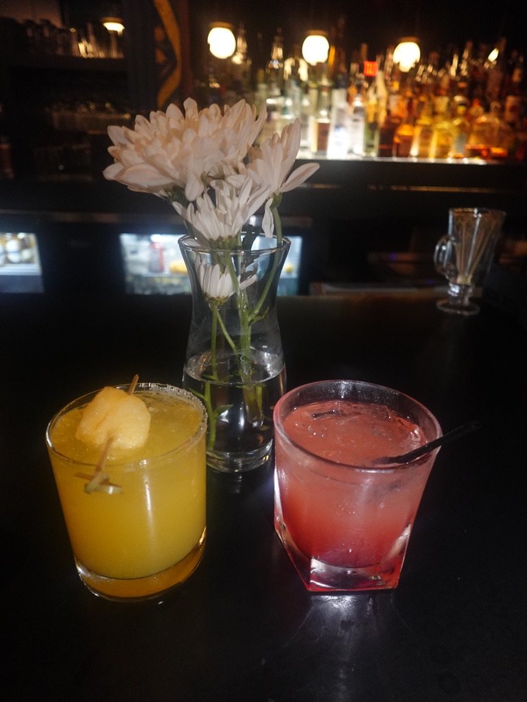 Cocktails served alongside fresh flowers on the table