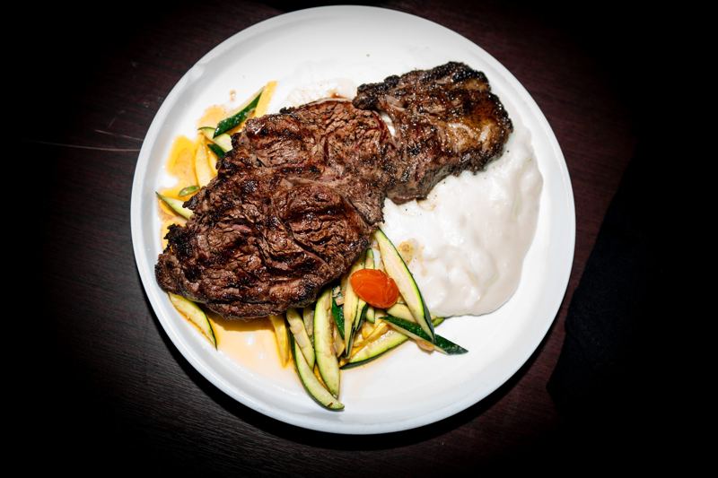 Grilled steak over whipped potato with seasonal vegetables